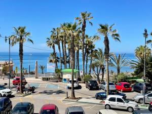 a parking lot with palm trees and the ocean at Geysotur Torrox Playa Apartamentos in Torrox