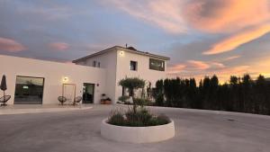 a white building with a sunset in the background at Hotel Síbel Baza in Baza