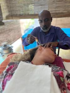 Eine Frau, die sich von einem Friseur die Haare schneiden lässt. in der Unterkunft Sirilaka Wedagedara in Alutwala