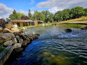 a river with rocks in front of a building at Pépites Lodges et Spas - Prémilhat in Prémilhat +25 photos
