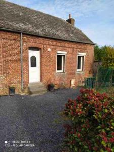 une vieille maison en briques avec une porte blanche et quelques fleurs dans l'établissement Single-story studio with parking, 