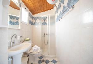 een badkamer met een wastafel en een douche bij Seaside Holiday House by elite in Psarou +21 foto's
