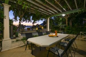 een tafel en stoelen op een patio met een pergola bij Ancora Mokalo Apartments in Jurjević