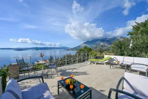 een patio met stoelen en uitzicht op het water bij Ancora Mokalo Apartments in Jurjević