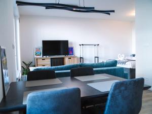 a living room with a table and a blue couch at Doctor's Cosy Apartment in Lamač