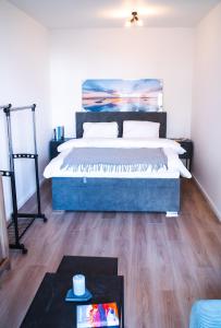 een slaapkamer met een groot bed en een houten vloer bij Doctor's Cosy Apartment in Lamač