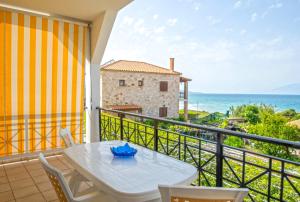un balcon avec une table et des chaises et l'océan dans l'établissement Seaside Holiday House by elite, à Psarou