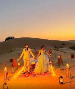 Una novia y un novio posando para una foto en el desierto en Ozaki Desert Camp & Resort, en Jaisalmer
