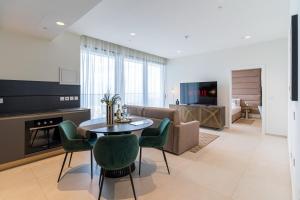 a living room with a table and a couch at 21st Floor Sunset Apartment - Mercury Tower with Pool Access by Stays Uniq in St. Julianʼs