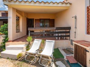 a pair of lawn chairs sitting on the front porch of a house at Porto Luna 25 - Hala in Simius +16 photos