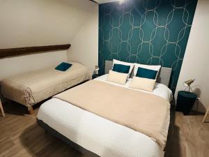 - une chambre avec 2 lits et un mur vert dans l'établissement Le Gîte Du Lavoir, à Courbouzon