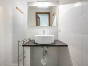 a white bathroom with a sink and a mirror at Porto Luna 25 - Hala in Simius