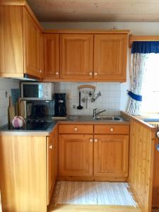 a kitchen with wooden cabinets and a sink at Haus Hinterseer in Schneizlreuth