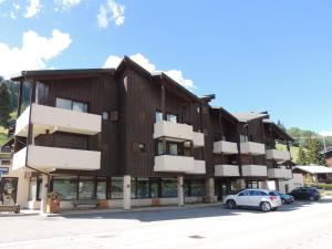 ein Mehrfamilienhaus mit auf einem Parkplatz geparkten Autos in der Unterkunft Duplex 3 pièces aux Gets, proche pistes avec parking et wifi - FR-1-598-23 in Les Gets