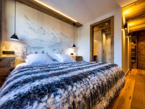 a bedroom with a large bed with a large wall at Appartement de Charme 4* au Centre des Gets - Accès Direct aux Pistes de Ski - FR-1-598-28 in Les Gets