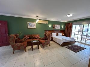 1 dormitorio con cama, sofá y sillas en Herrmes, en Sharm El Sheikh 32 fotos más