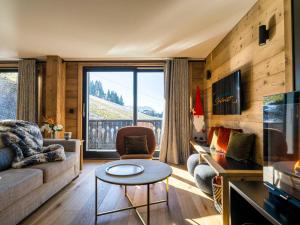 a living room with a couch and a table at Appartement de Charme 4* au Centre des Gets - Accès Direct aux Pistes de Ski - FR-1-598-28 in Les Gets