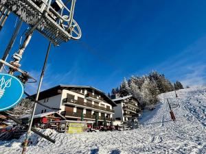 a ski lift in front of a building in the snow at Appartement de Charme 4* au Centre des Gets - Accès Direct aux Pistes de Ski - FR-1-598-28 in Les Gets
