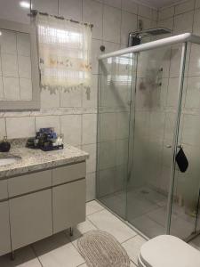 une salle de bain avec une douche en verre et des toilettes dans l'établissement Andradas House - Casa em Uruguaiana, à Uruguaiana 21 autres photos