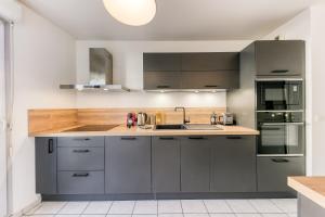 马西Bright & Chill - Terrasse - À 7 min Gare Massy TGV的配有灰色橱柜和水槽的厨房