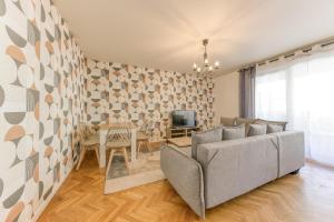 马西Bright & Chill - Terrasse - À 7 min Gare Massy TGV的客厅里有一张沙发和一张桌子。