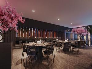 a dining room with tables and chairs and pink flowers at Muro Alto em Porto de Galinhas Apto Alto Padrão in Ipojuca