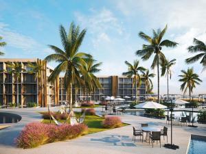 a resort with tables and chairs and palm trees at Muro Alto em Porto de Galinhas Apto Alto Padrão in Ipojuca