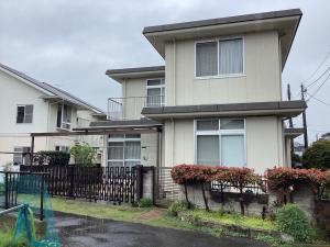 ein Haus mit einem Zaun davor in der Unterkunft Lemon Sou Guest House - Vacation STAY 16205 in Ichihara