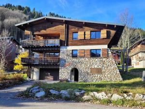 a large wooden house with a stone facade at Chalet familial rénové, proche centre, capacité 12, parking, WiFi - FR-1-598-195 in Les Gets