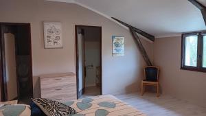 a bedroom with a bed and a window and a chair at Au Moulin du Comte - en gîte in Bourrouillan