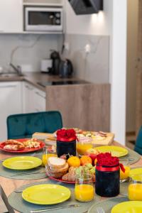 stół z talerzami jedzenia i soku pomarańczowego w obiekcie Bory6a Apartamenty & Free Parking w Zakopanem