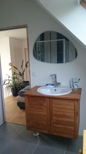 ein Badezimmer mit Waschbecken und Spiegel in der Unterkunft Chambre chez l'habitant in Crach