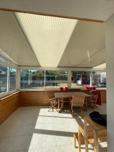 ein Raum mit Tisch und Stühlen und Fenstern in der Unterkunft Chambre chez l'habitant in Crach