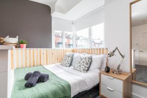 a bedroom with a bed with pillows and a mirror at Stylish Studio Apt in Leeds in Headingley