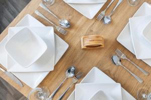 a table with white plates and silver utensils at Stylish Studio Apt in Leeds in Headingley