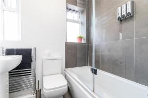 a bathroom with a toilet and a sink and a bath tub at Stylish Studio Apt in Leeds in Headingley +9 photos