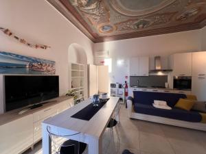 ein Wohnzimmer mit einer blauen Couch und einer Küche in der Unterkunft LA CASA ROSA AL MARE RAPALLO, Central Seafront Stay, Air Conditioning, Wi-Fi, the Ideal Choice for a Relaxing and Exciting Coastal Escape, with available on request at 20,00 euro per night Private Garage, Welcome kit Priority, Prosecco and Canestrelli in Rapallo