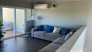 ein Wohnzimmer mit Sofa und blauen Kissen in der Unterkunft Aquatika 3 Bed 2 Bath 2 Par in Vieques
