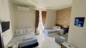 a room with two beds and a television in it at One Season Cairo in Cairo