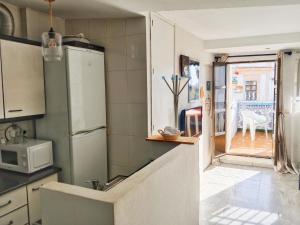 eine Küche mit Kühlschrank und Mikrowelle in der Unterkunft Ático San Agustín - Panoramic View in Jerez de la Frontera