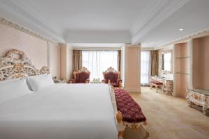 ein Schlafzimmer mit einem großen weißen Bett in einem Zimmer in der Unterkunft Nanyang King's Gate Hotel--Free Shuttle Service to Canton Fair in Guangzhou + 44 Fotos