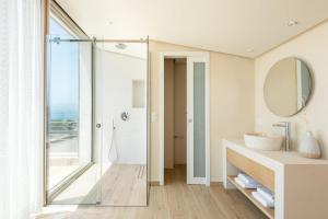 ein Badezimmer mit Glasdusche und Waschbecken in der Unterkunft Luria Homes in Lagomandra + 67 Fotos