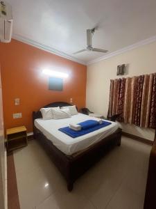 a bedroom with a bed with a blue blanket on it at HOTEl BOMMANA RESIDENCY in Godāvari