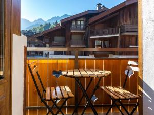 a table and two chairs on a balcony at Appartement 2 chambres centre village proche pistes avec Wifi - FR-1-437-60 in La Clusaz