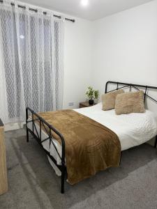 a bedroom with a large bed with a metal frame at Seabreeze Suits Boscombe in Bournemouth