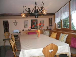 une table de salle à manger avec un vase de fleurs dessus dans l'établissement Almhaus Am Hohenwart, à Klippitztorl