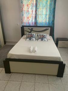 - un lit avec 2 chaussures blanches au-dessus dans l'établissement Appartement charmant avec vue sur la ville à Anse-Bertrand 45m², à Malgrétout 22 autres photos