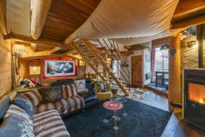 un salon avec un canapé et une cheminée dans l'établissement Le Cosy Lodge, à Le Bourg d'oisans