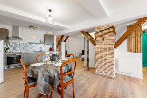 eine Küche und ein Esszimmer mit Tisch und Stühlen in der Unterkunft Le Loft du Castel Bas - Pause au cœur du Tarn in Castelnau-de-Montmiral