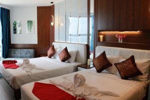 a hotel room with two beds with towels on them at Apec Mui Ne Chill Sea View in Ấp Thiẹn Ái